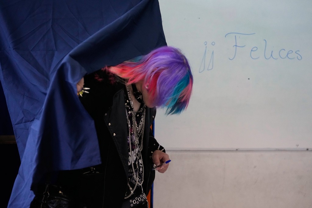 A voter leaves the booth where ballots are marked during the presidential runoff election in Santiago, Chile, Sunday, Dec. 14, 2025. (AP Photo/Matias Delacroix)