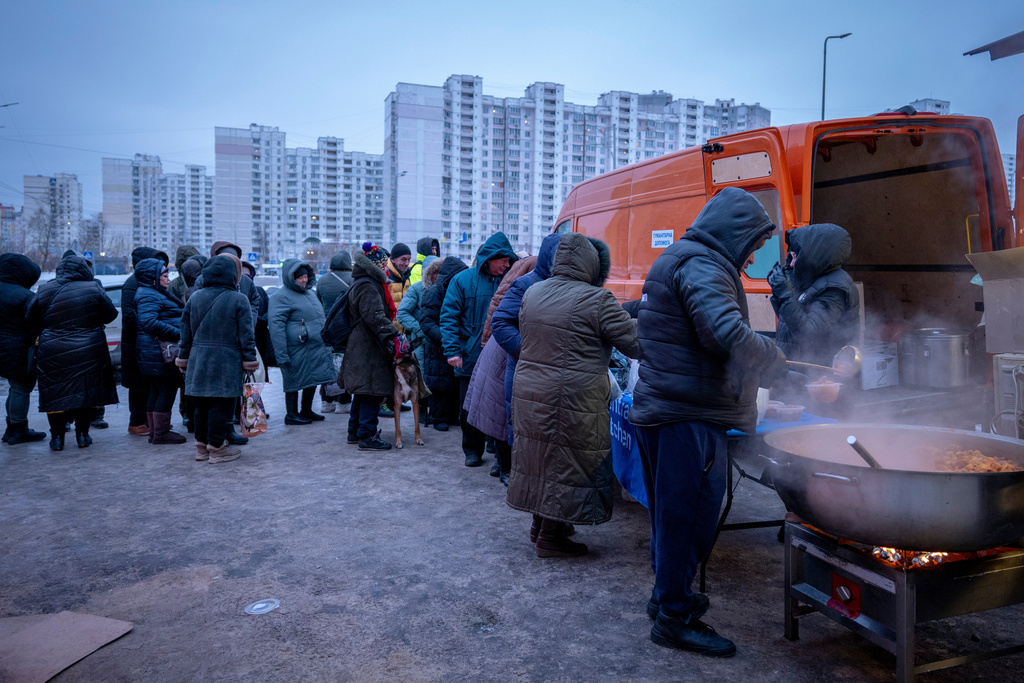 People who have no power at home following Russia's air attacks wait in line to receive free hot meals in a residential neighbourhood in Kyiv, Ukraine, Friday, Jan. 30, 2026. (AP Photo/Dan Bashakov)
