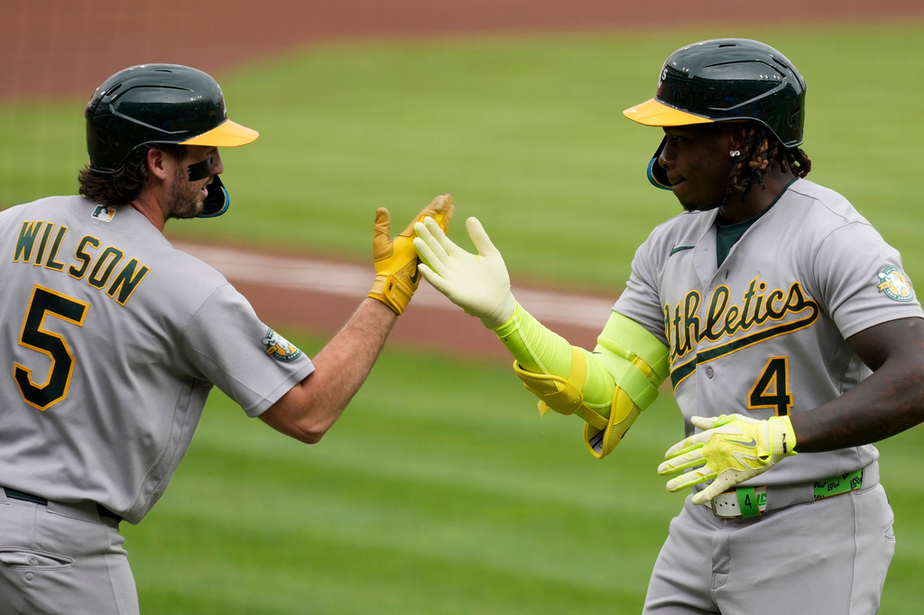 Athletics' Lawrence Butler (4) celebrates with Jacob Wilson (5) after Butler hit a solo home run during the first inning of a baseball game against the Cincinnati Reds in Cincinnati, Wednesday, Aug. 5, 2026. (AP Photo/Carolyn Kaster)