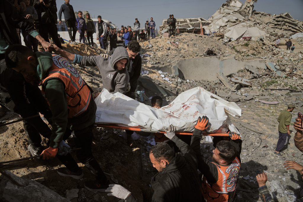 Palestinians carry a body from the rubble of police station after it was targeted by an Israeli army strike in Gaza City Saturday, Jan. 31, 2026. (AP Photo/Jehad Alshrafi)