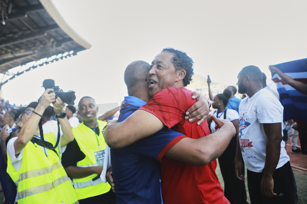 Two men celebrate after Cape Verde defeated Eswatini in a World Cup qualifying soccer match at Estádio Nacional in Praia, Cape Verde, Monday, Oct. 13, 2025, to clinch their qualification for the 2026 World Cup. (AP Photo/Cristiano Barbosa)