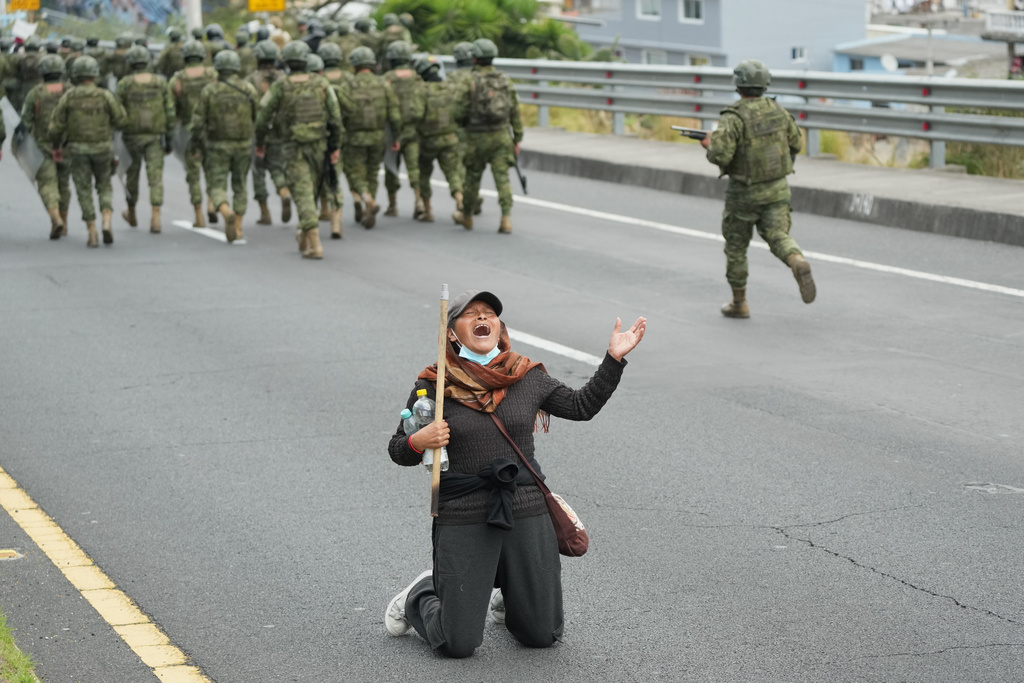 A woman shouts as soldiers arrive to clear the Pan-American Highway of demonstrators protesting the elimination of diesel subsidy by President Daniel Noboa's government, in Calderon, Ecuador, Thursday, Oct. 9, 2025. (AP Photo/Dolores Ochoa)