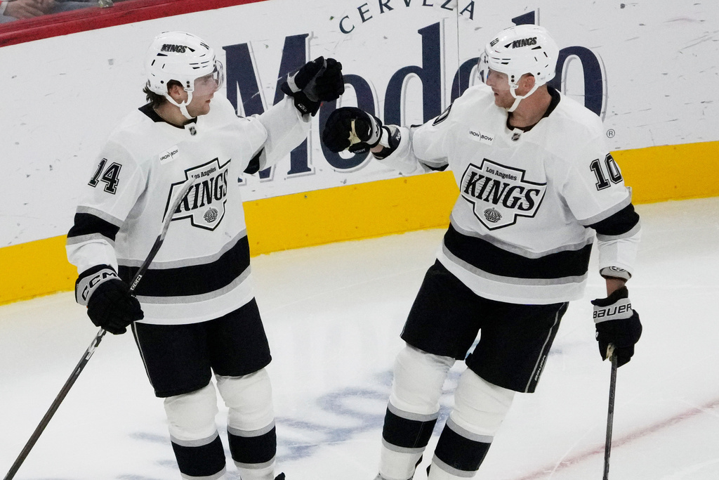 Los Angeles Kings right wing Alex Laferriere, left, celebrates with Corey Perry, right, after his goal against the Chicago Blackhawks during the second period of an NHL hockey game Sunday, Oct. 26, 2025, in Chicago. (AP Photo/David Banks)