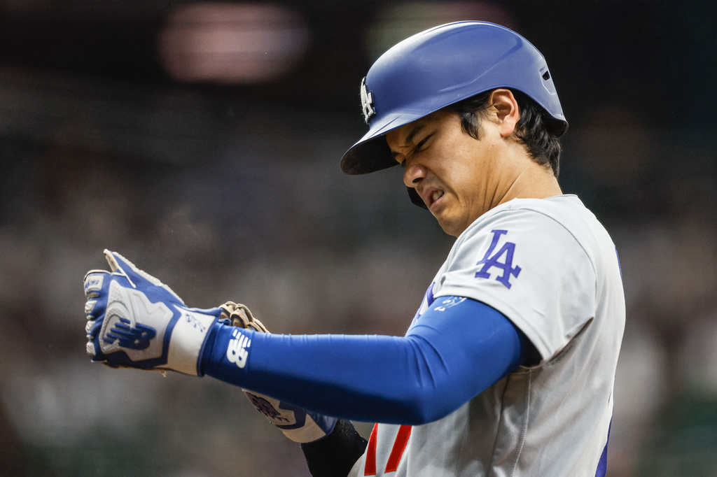 Los Angeles Dodgers two-way player Shohei Ohtani adjusts his gloves at first base during the first inning of a baseball game against the Milwaukee Brewers, Friday, May 22, 2026, in Milwaukee. (AP Photo/Jeffrey Phelps)