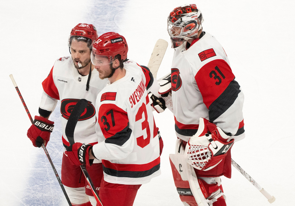 Carolina Hurricanes' Sebastian Aho (20) and Andrei Svechnikov (37) celebrate in front of Hurricanes goaltender Frederik Andersen (31) after the winning goal by Aho in overtime of Game 3 of the Eastern Conference finals NHL hockey Stanley Cup playoff series against the Montreal Canadiens in Montreal, Monday, May 25, 2026. (Christinne Muschi/The Canadian Press via AP)