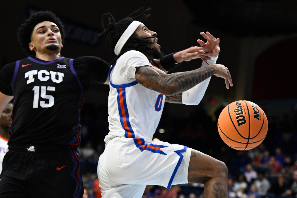 Florida guard Boogie Fland (0) is fouled by TCU forward David Punch (15) during the first half of an NCAA college basketball game in the Rady Children's Invitational tournament Thursday, Nov. 27, 2025, in San Diego. (AP Photo/Denis Poroy)