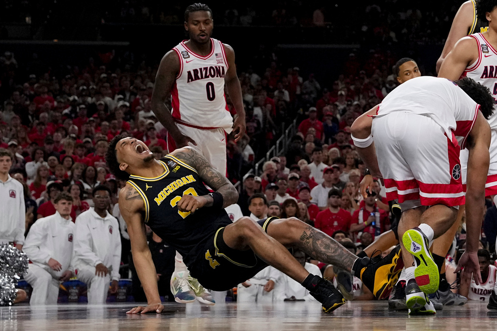 Michigan forward Yaxel Lendeborg (23) falls after play against Arizona during the first half of an NCAA college basketball tournament semifinal game at the Final Four, Saturday, April 4, 2026, in Indianapolis. (AP Photo/Abbie Parr)