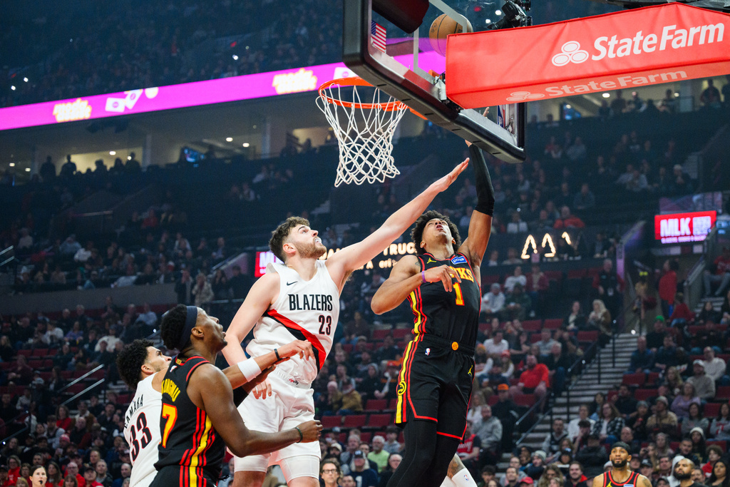 Portland Trail Blazers center Donovan Clingan (23) reaches out to block a basket from Atlanta Hawks forward Jalen Johnson (1) during the first half of an NBA basketball game on Thursday, Jan. 15, 2026, in Portland, Ore. (AP Photo/Molly J. Smith)