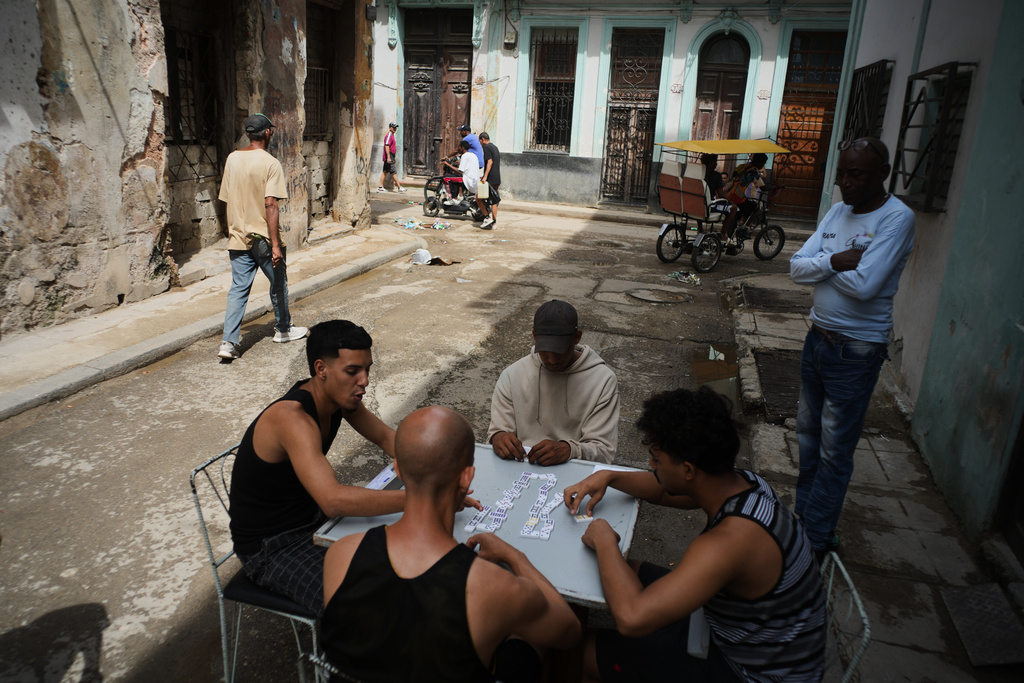 People play dominoes outside during a blackout in Havana, Tuesday, March 17, 2026. (AP Photo/Ramon Espinosa)
