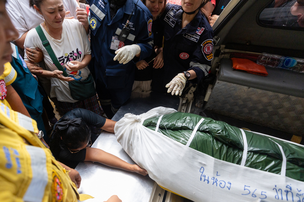A woman weeps beside the body of a victim of a school shooting in Thailand's Nonthaburi province, Friday, Aug. 7, 2026. (AP Photo/Wason Wanichakorn)