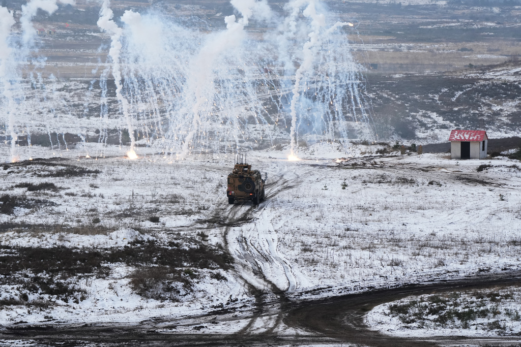 Soldiers drive a vehicle as they work to extract and secure an enemy in a mock village during NATO led military exercises at a military base near Bergen, Germany, Thursday, Feb. 19, 2026. (AP Photo/Virginia Mayo)