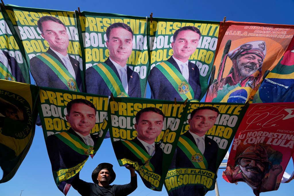 FILE - A street vendor sells campaign flags of presidential candidates Sen. Flavio Bolsonaro and current President Luiz Inacio Lula da Silva, who is running for reelection, in Brasilia, Brazil, Sept. 29, 2026. (AP Photo/Eraldo Peres, File)