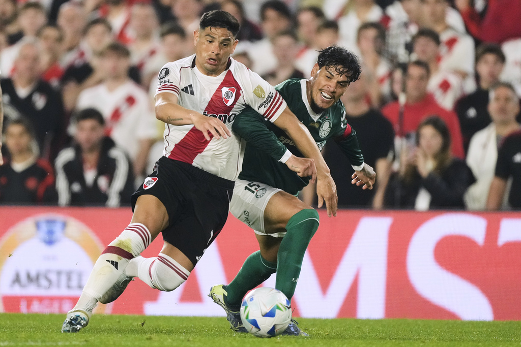 Maximiliano Salas of Argentina's River Plate, left, and Gustavo Gomez of Brazil's Palmeiras battle for the ball during a Copa Libertadores quarterfinal soccer match at the Monumental stadium in Buenos Aires, Argentina, Wednesday, Sept. 17, 2025. (AP Photo/Gustavo Garello)