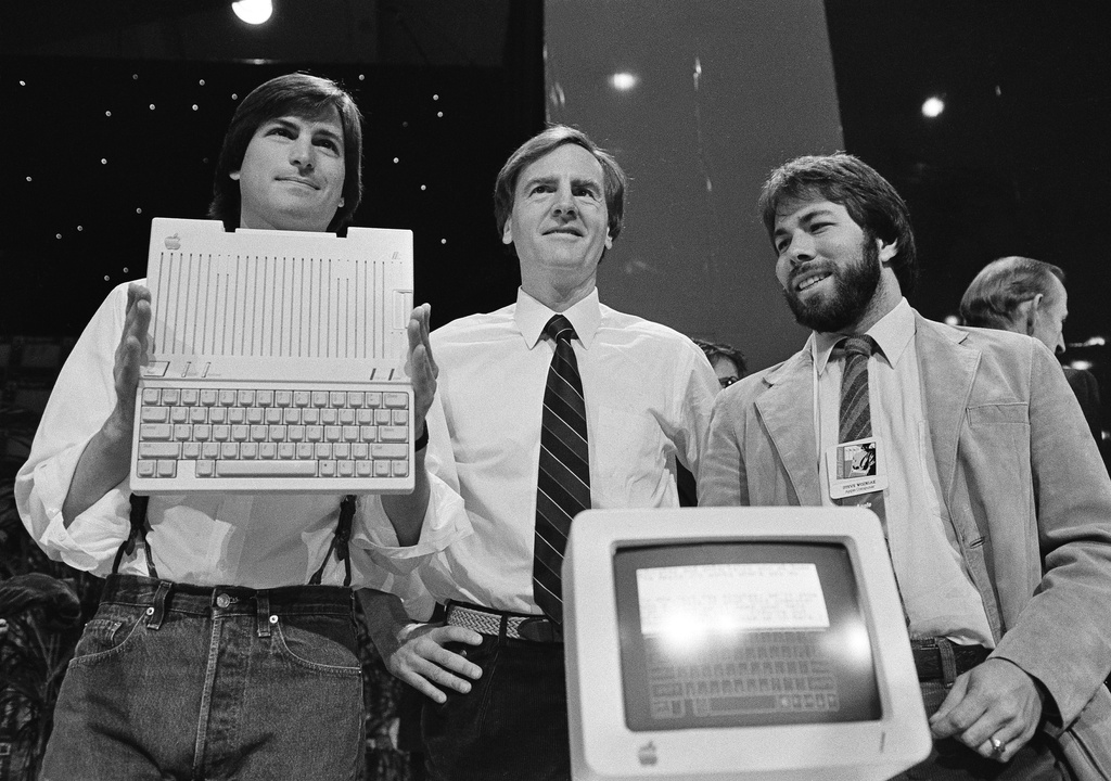 FILE - Steve Jobs, left, chairman of Apple Computers, John Sculley, center, president and CEO, and Steve Wozniak, co-founder of Apple, unveil the new Apple IIc computer in San Francisco, Calif., April 24, 1984. (AP Photo/Sal Veder, File)