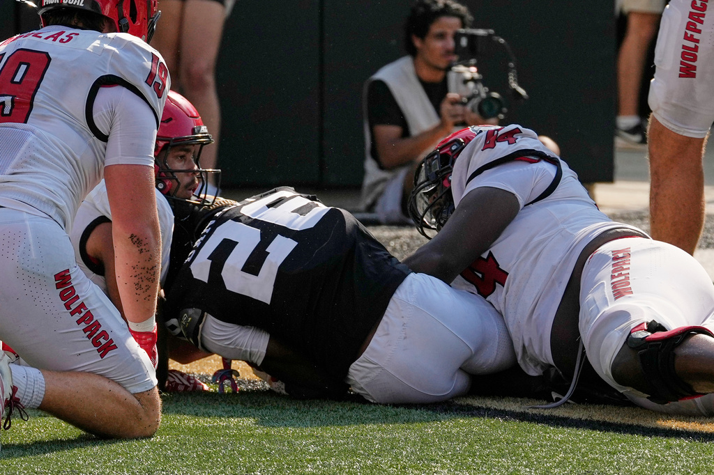 Vanderbilt cornerback Cayden Daniels, center, recovers a North Carolina State fumble in the end zone for a touchdown during the second half of an NCAA college football game Saturday, Sept. 19, 2026, in Nashville, Tenn. (AP Photo/George Walker IV)