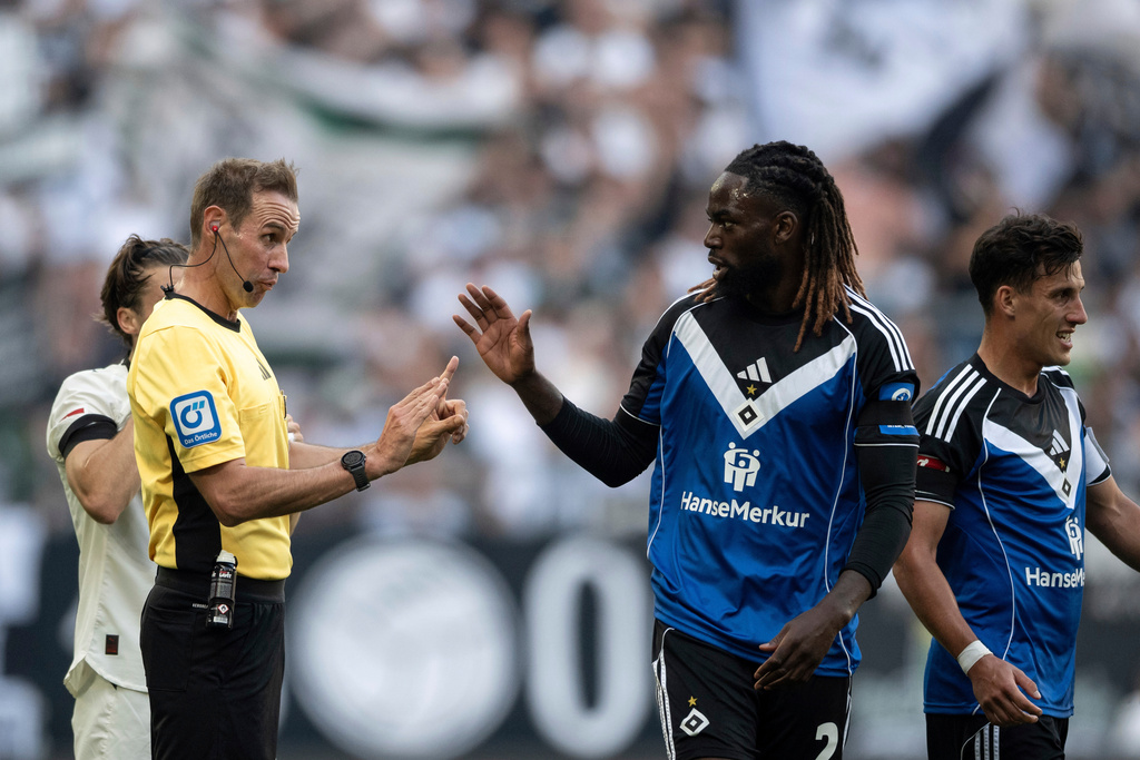 Referee Sascha Stegemann talks to Hamburg's Jordan Torunarigha during the German Bundesliga soccer match between Borussia Mönchengladbach and Hamburger SV at Borussia-Park in Mönchengladbach, Germany, Sunday Aug. 24, 2025. (Fabian Strauch/dpa via AP)