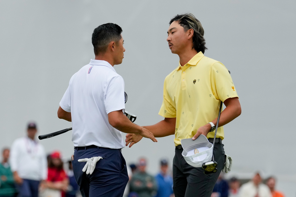 USA teams' Collin Morikawa, left, greets International teams' Min Woo Lee, of Australia, after their Presidents Cup golf tournament second round foursomes match at Medinah Country Club, Friday, Sept. 25, 2026, in Medinah, Ill. (AP Photo/Chris Carlson)