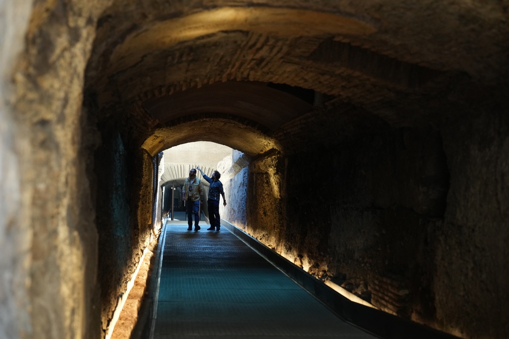 Workers walk in the so-called 'Passage of Emperor Commodus', a newly restored tunnel ancient Roman emperors would use to enter the Colosseum unseen and protected, that will open to visitors at the end of the month, in Rome, Wednesday, Oct. 8, 2025. (AP Photo/Andrew Medichini)