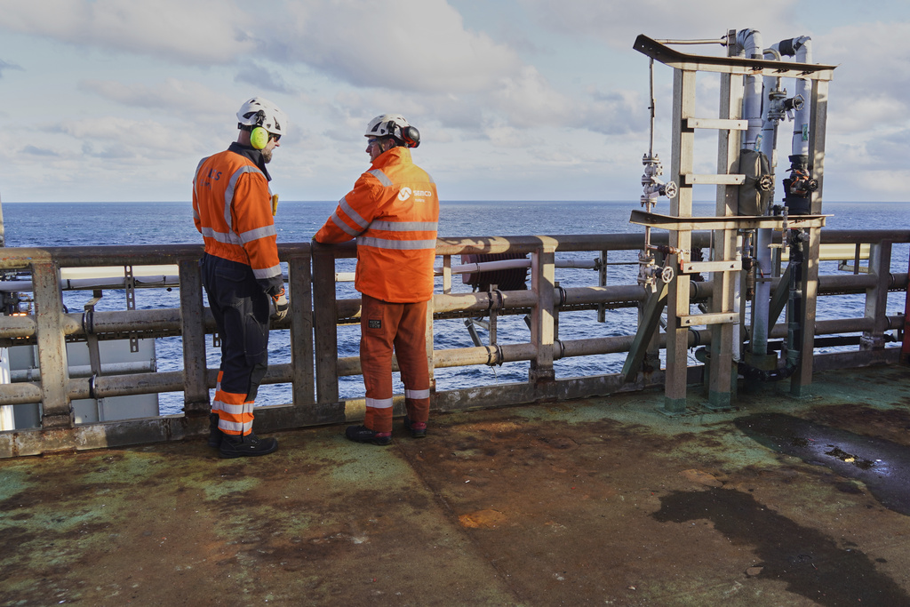 Workers stand at the platform's railing on the INEOS Energy's Siri platform in the North Sea, Denmark, Tuesday, Nov. 25, 2025. (AP Photo/James Brooks)
