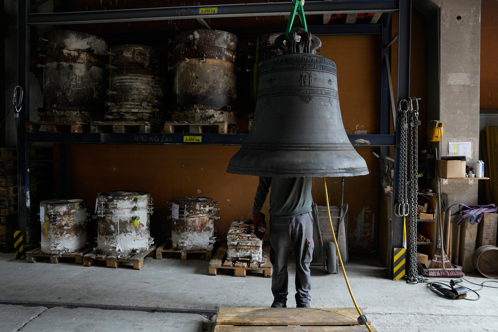 An employee works on the inside of a bell at the 400-year-old family-owned bell foundry Grassmayr in Innsbruck, Austria, Friday, July 17, 2026. (AP Photo/Matthias Schrader)