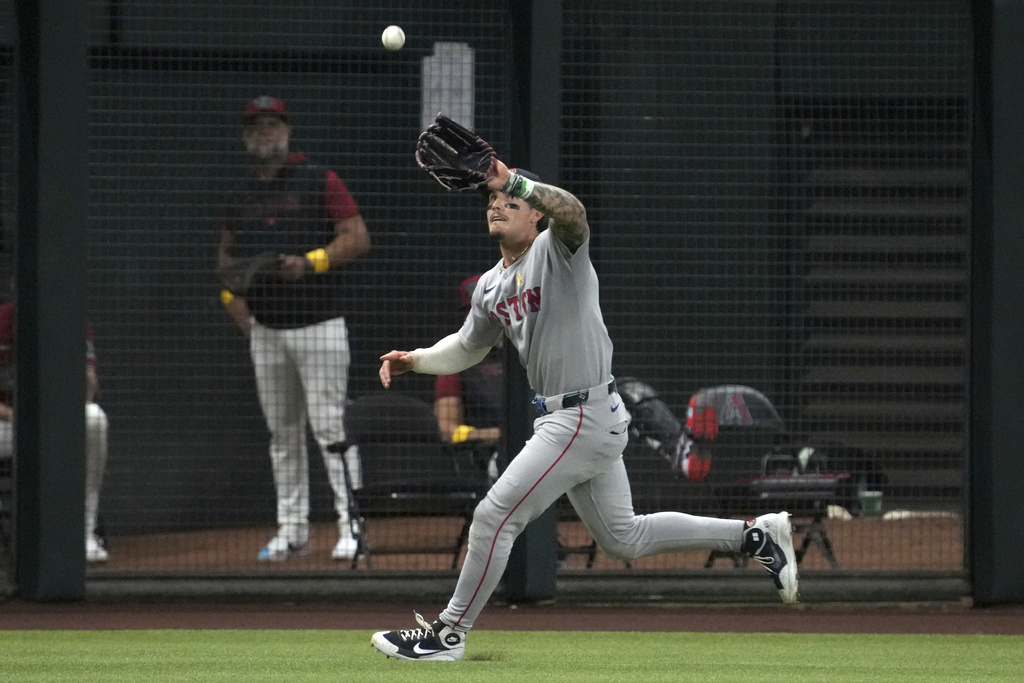 Boston Red Sox left fielder Jarren Duran makes a running catch on a ball hit by Arizona Diamondbacks' Geraldo Perdomo in the sixth inning of a baseball game, Sunday, Sept 7, 2025, in Phoenix. (AP Photo/Rick Scuteri)