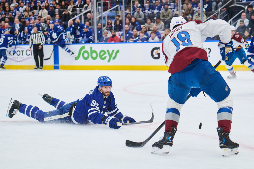 Toronto Maple Leafs' Oliver Ekman-Larsson (95) dives for the puck as Colorado Avalanche's Jack Drury (18) lines up a shot during first period NHL hockey action in Toronto, on Sunday, Jan. 25, 2026. (Sammy Kogan/The Canadian Press via AP)