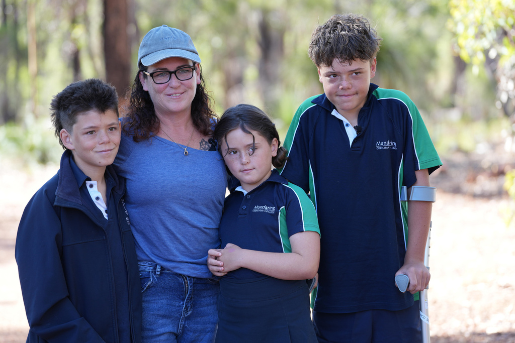 Austin Appelbee, right, poses with his brother, Beau, left, his mother, Joanne, second left, and sister Grace, in Gidgegannup, Australia, Tuesday Feb. 3, 2026, after 13-year-old Austin made an hourslong swim to raise an alarm after his family was swept out to sea off the Australian coast. (Briana Shepherd/ABC via AP)