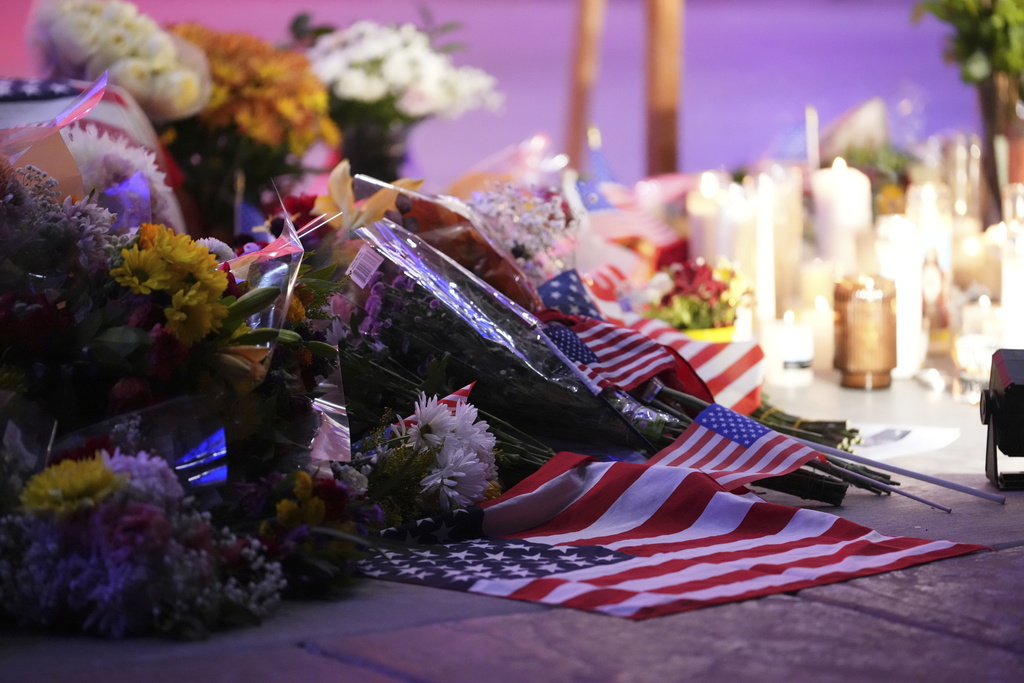 Flowers, candles and American flags sit at a vigil for Charlie Kirk, the CEO and co-founder of Turning Point USA who was shot and killed, Thursday, Sept. 11, 2025, in Orem, Utah. (AP Photo/Lindsey Wasson)