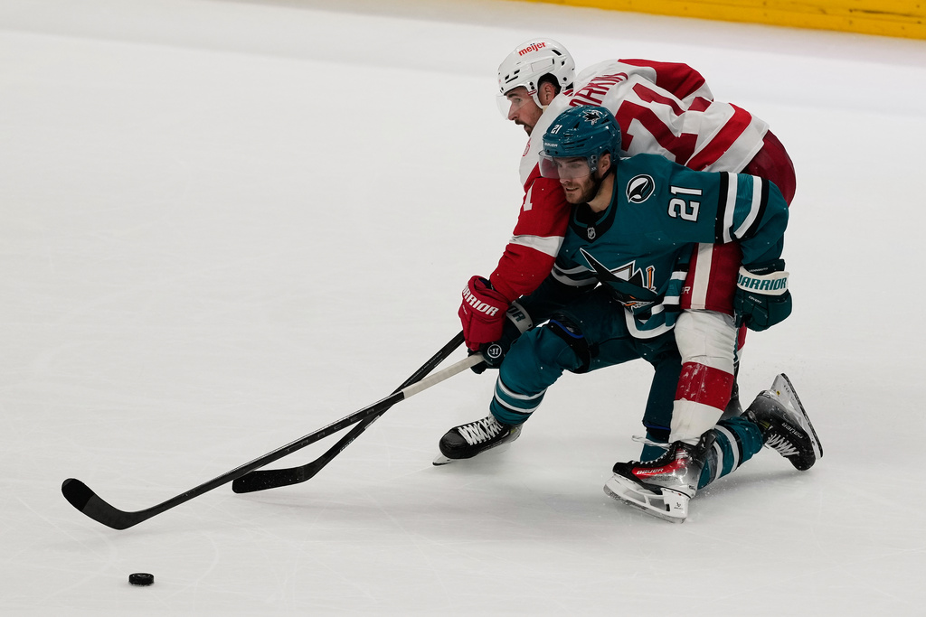 Detroit Red Wings center Dylan Larkin, top, reaches for the puck over San Jose Sharks center Alexander Wennberg (21) during overtime of an NHL hockey game in San Jose, Calif., Sunday, Nov. 2, 2025. (AP Photo/Jeff Chiu)