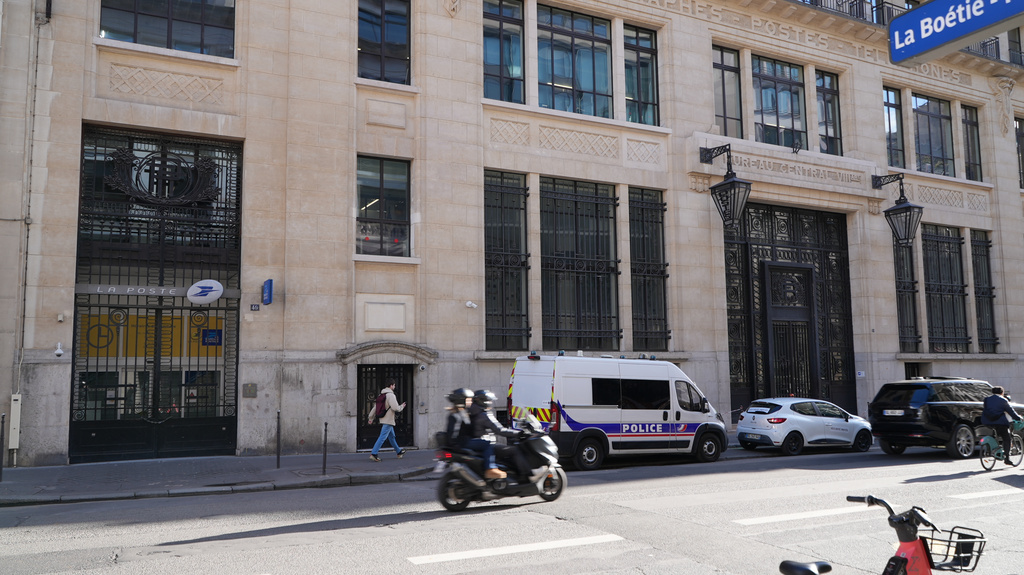 Police stand outside the Bank of America building in Paris, Saturday, March 28, 2026. (AP Photo/Nicolas Garriga)
