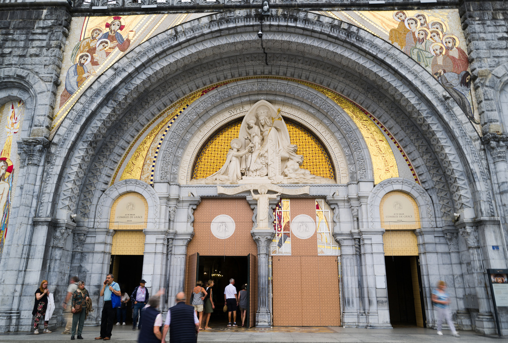 People enter the Notre-Dame-du-Rosaire basilica in Lourdes, southwestern France, Tuesday Sept. 8, 2026 . (AP Photo/Fred Scheiber)