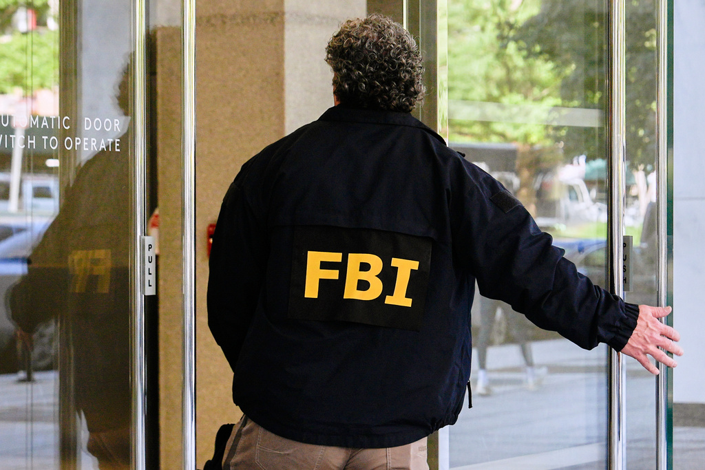 FILE - An FBI agent walks inside the front entrance of ex-Trump national security adviser John Bolton's Washington office, Aug 22, 2025. (AP Photo/Julia Demaree Nikhinson, File)