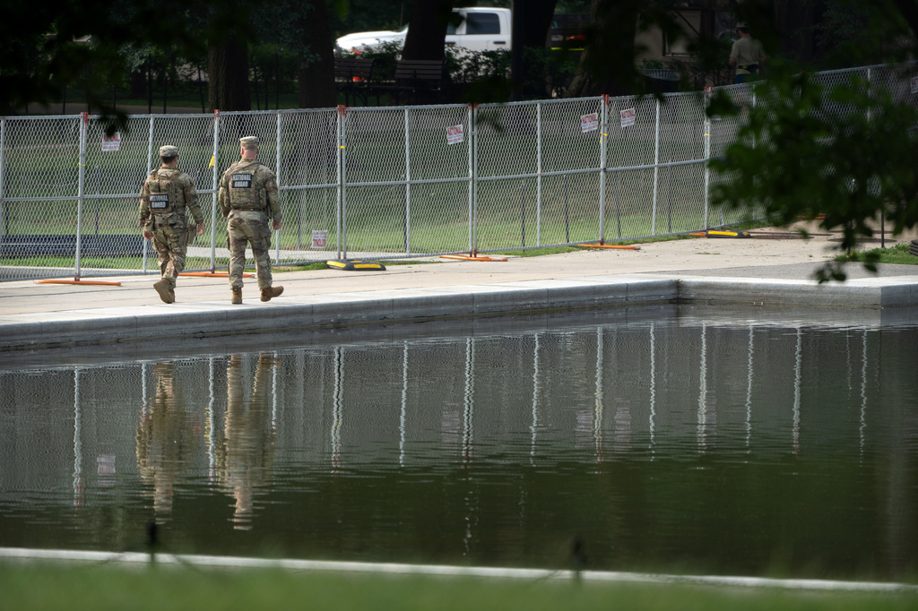 National Guard members walk near the Lincoln Memorial Reflecting Pool, Friday, July 10, 2026, in Washington. (AP Photo/Mark Schiefelbein)