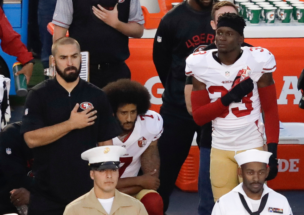 FILE - San Francisco 49ers quarterback Colin Kaepernick, middle, kneels during the national anthem before the team's NFL preseason football game against the San Diego Chargers, Thursday, Sept. 1, 2016, in San Diego. (AP Photo/Chris Carlson, File)