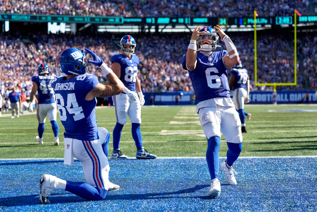 New York Giants tight end Theo Johnson (84) and quarterback Jaxson Dart (6) celebrate after Johnson scored a touchdown against the Los Angeles Chargers during the third quarter of an NFL football game, Sunday, Sept. 28, 2025, in East Rutherford, N.J. (AP Photo/Yuki Iwamura)