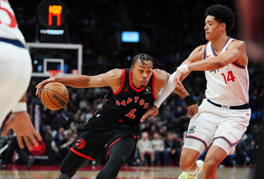 Toronto Raptors' Scottie Barnes (4) drives past Los Angeles Clippers' Yanic Konan Niederhauser (14) during second-half NBA basketball game action in Toronto, Friday, Jan. 16, 2026. (Frank Gunn/The Canadian Press via AP)