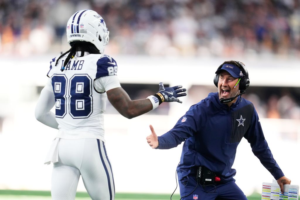 Dallas Cowboys head coach Brian Schottenheimer, right, greets wide receiver Ceedee Lamb (88) near the bench after a touchdown against the Washington Commanders during the second half of an NFL football game Sunday, Oct. 19, 2025, in Arlington, Texas. (AP Photo/Jeffrey McWhorter)