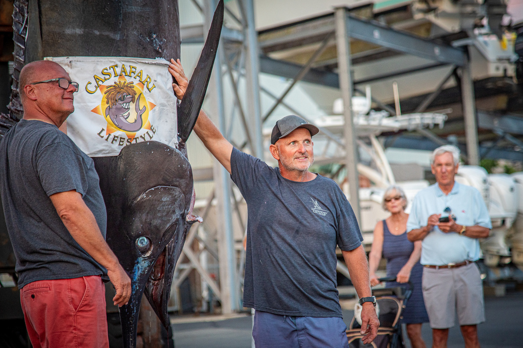 This photo provided by Jimmy Fee shows Walter Chapman, left, and Damon Sacco, captain of the Castafari, right, posing with an enormous blue marlin that they caught off the coast of Massachusetts, Wednesday, Aug. 19, 2026, in Falmouth, Mass. (Jimmy Fee via AP)