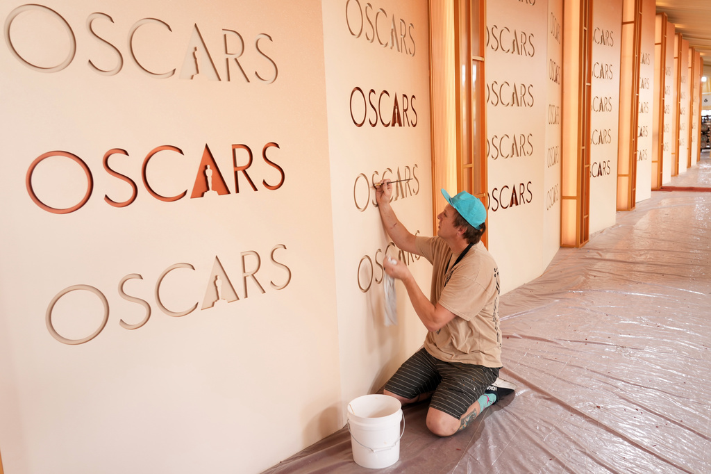 Motion picture painter Chance Gugler, whose father was also a film set painter who worked on over 80 movies, touches up an Oscars backdrop on Friday, March 13, 2026, at the Dolby Theatre in Los Angeles, in preparation for Sunday's Academy Awards ceremony. (AP Photo/Chris Pizzello)