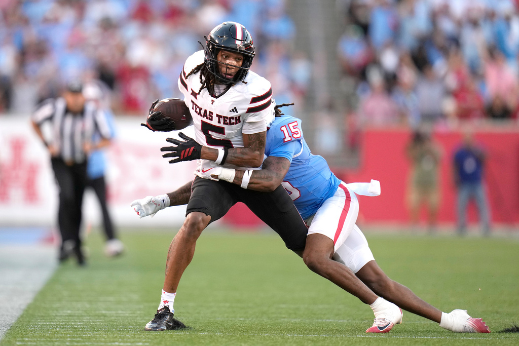 Texas Tech wide receiver Caleb Douglas (5) is tackled by Houston defensive back Will James (15) after catching a pass during the first half of an NCAA college football game, Saturday, Oct. 4, 2025, in Houston. (AP Photo/Karen Warren)