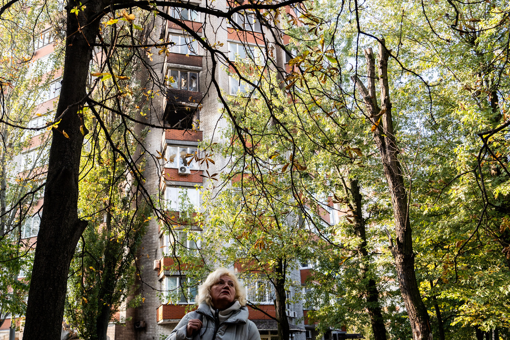 A woman looks at damage to an apartment building following Russian attacks, Wednesday, Oct. 22, 2025, in Kyiv, Ukraine. (AP Photo/Julia Demaree Nikhinson)