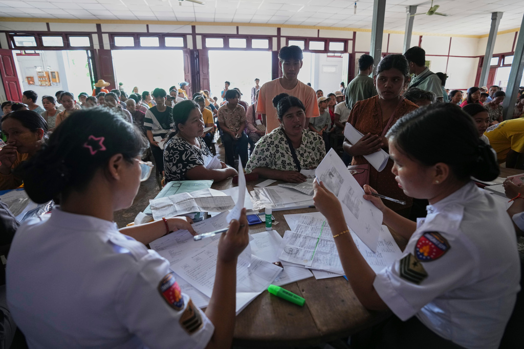 In this photo taken during a trip supervised by pro-military Myanmar media, immigration officers check personal data of locals for lost and damaged national registration cards, at a temporary office in Kyaukme, northern Shan State, Myanmar, Friday, Oct. 10, 2025. (AP Photo/Aung Shine Oo)