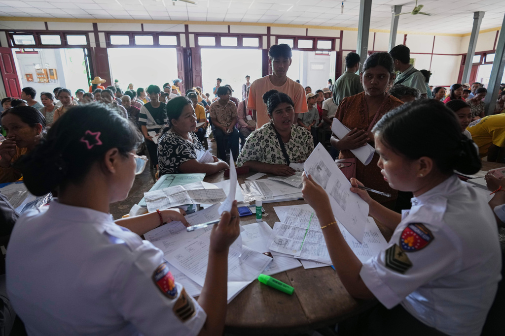 In this photo taken during a trip organised by pro-military Myanmar media, immigration officers check personal data of locals for lost and damaged national registration cards, at a temporary office in Kyaukme, northern Shan State, Myanmar, Friday, Oct. 10, 2025. (AP Photo/Aung Shine Oo)