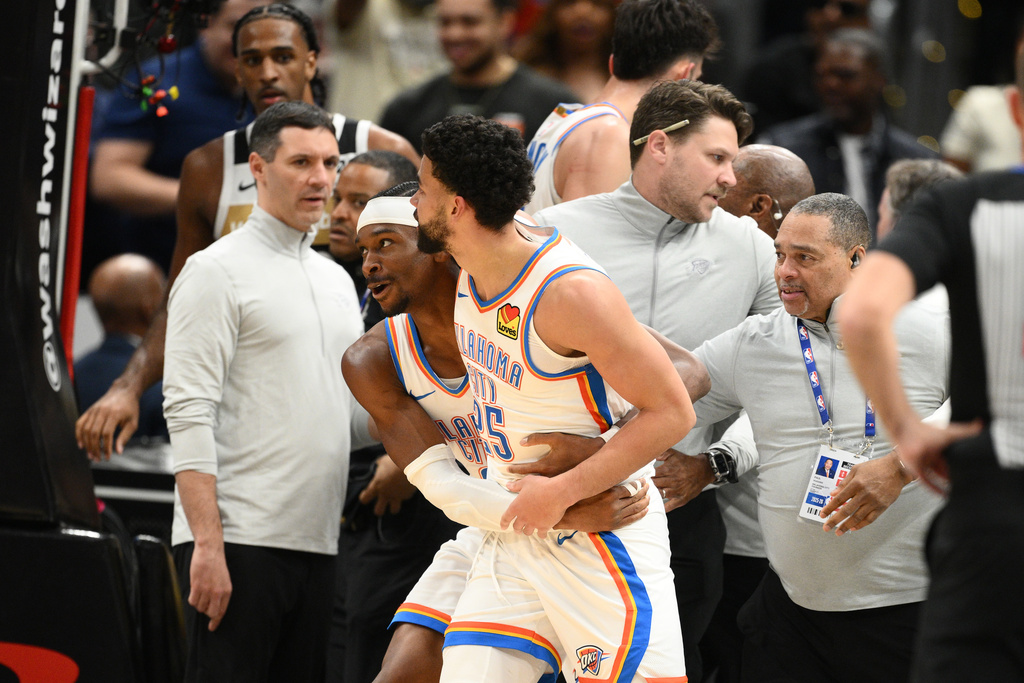 Oklahoma City Thunder guard Shai Gilgeous-Alexander, center left, grabs teammate guard Ajay Mitchell (25) after a scuffle with the Washington Wizards during the first half of an NBA basketball game, Saturday, March 21, 2026, in Washington. (AP Photo/Nick Wass)