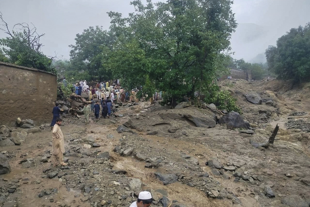 In this photo released by Rescue 1122 Emergency Department, rescue workers and local residents gather at the site of a massive cloudburst led to flash flooding in Salarzai, Pakistan, Friday, Aug. 15, 2025. (Rescue 1122 Emergency Department via AP)