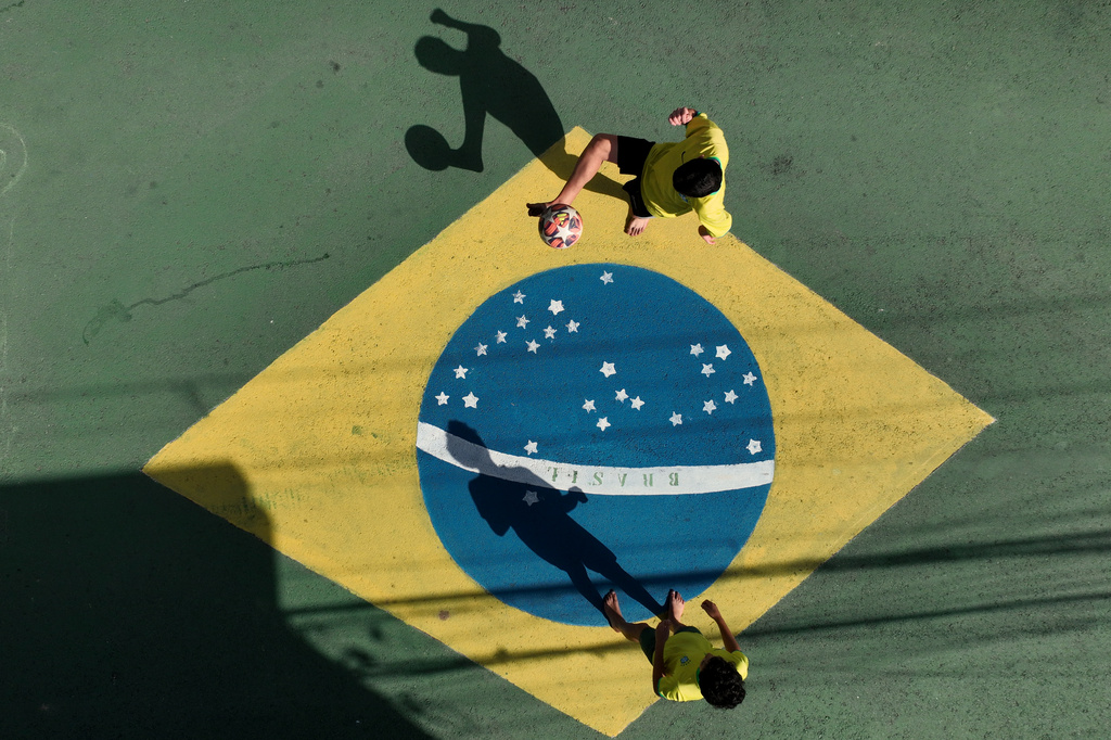 Boys play soccer on a decorated street in Osasco, in the greater Sao Paulo area, Brazil, Friday, June 5, 2026, ahead of the World Cup soccer tournament. (AP Photo/Andre Penner)