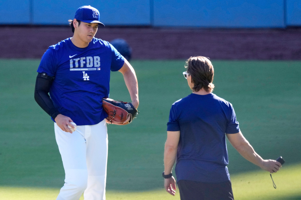 Los Angeles Dodgers' Shohei Ohtani warms up with a trainer prior to a baseball game against the Pittsburgh Pirates, Friday, Aug. 21, 2026, in Los Angeles. (AP Photo/Mark J. Terrill)