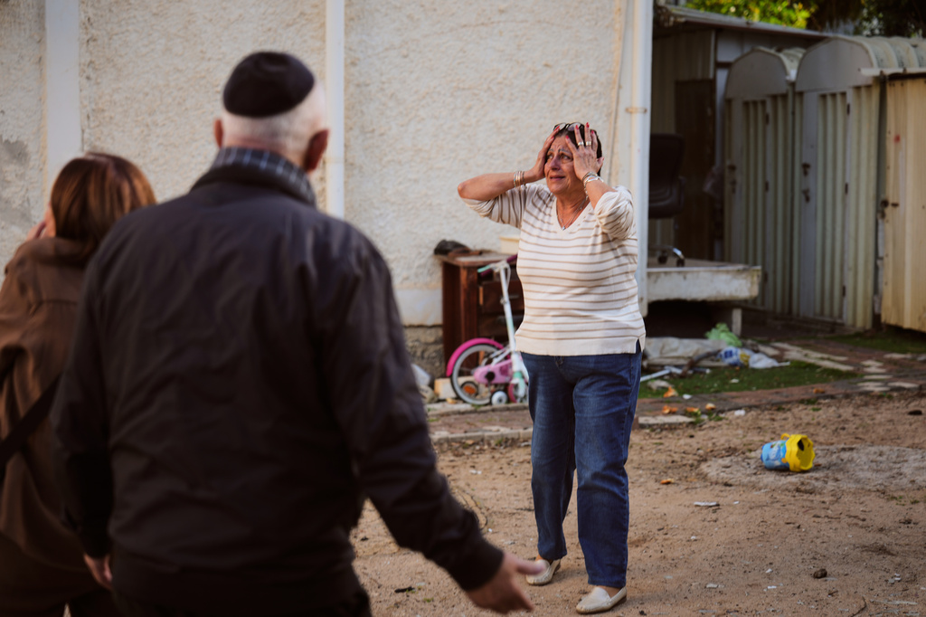A woman reacts at the site of a damaged residential building after it was struck by a projectile fired from Lebanon, in Nahariya, northern Israel Monday, April 13, 2026. (AP Photo/Ariel Schalit)