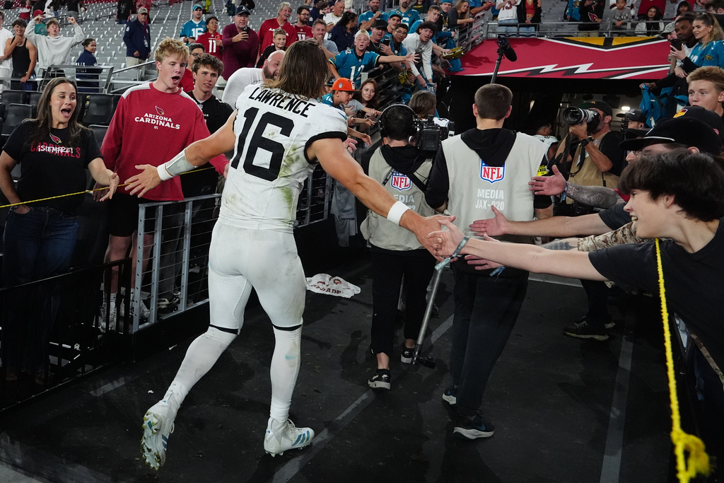 Jacksonville Jaguars quarterback Trevor Lawrence greets fans as he leaves the field after an NFL football game against the Arizona Cardinals Sunday, Nov. 23, 2025, in Glendale, Ariz. (AP Photo/Ross D. Franklin)