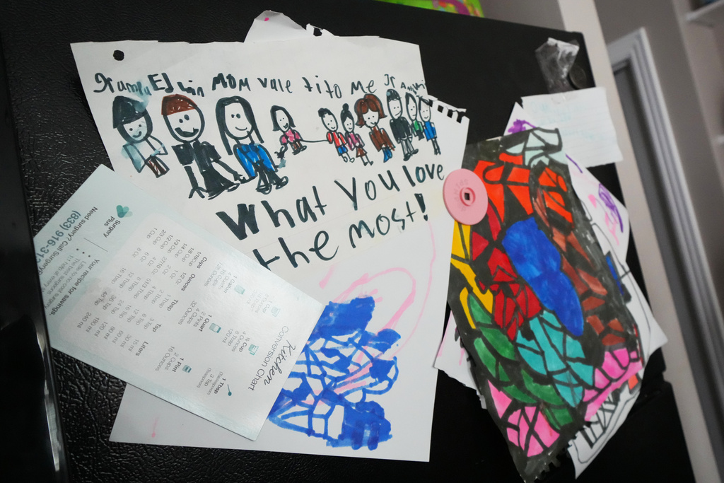 A child's drawing showing Edwin Sanchez-Mendoza and Cristina Osornio's family is seen on their refrigerator, Nov. 18, 2025, in Rogers, Ark. (AP Photo/Julio Cortez)